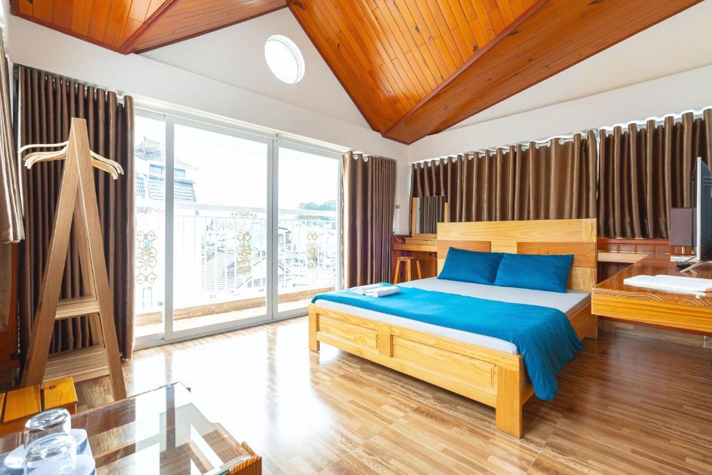 a bedroom with a bed and a large window at Gia Pham Hotel in Da Lat