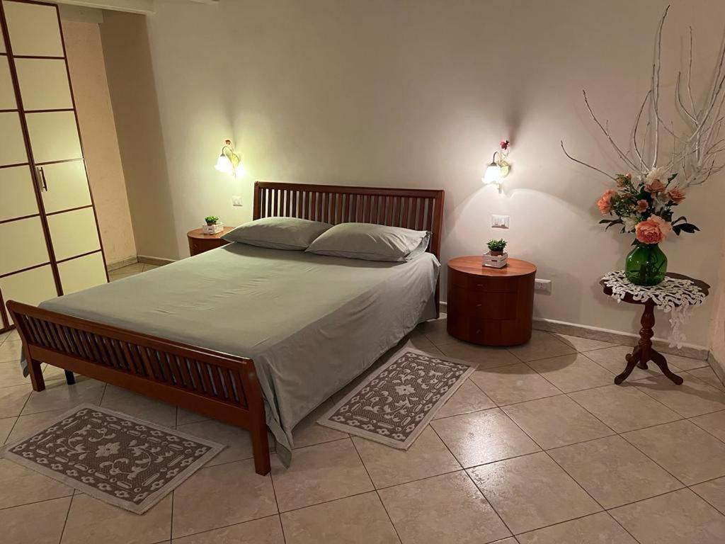 a bedroom with a large bed and two night stands at La casa di Ladì in Scilla