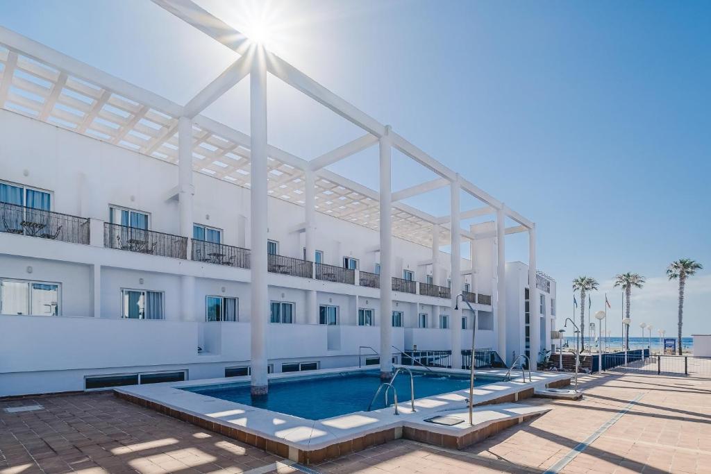 a large white building with a swimming pool at Hotel Don Ignacio in San José