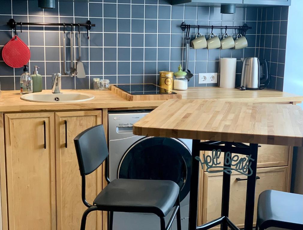 cocina con mesa, sillas y fregadero en Apartment Sigulda en Sigulda