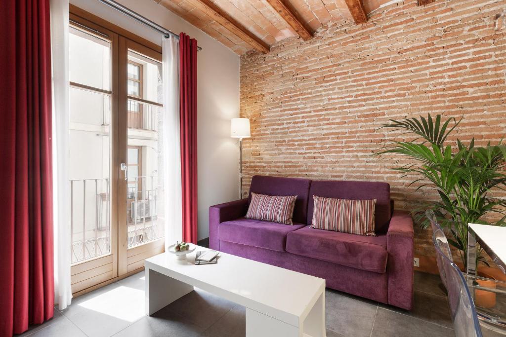 sala de estar con sofá púrpura y pared de ladrillo en Ola Living MACBA, en Barcelona