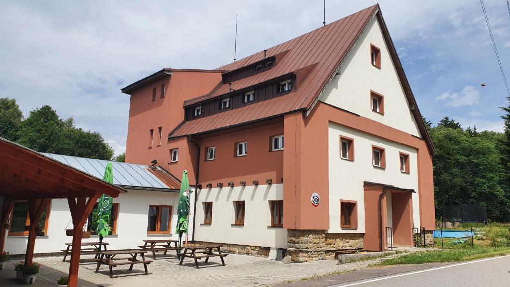 a large building with picnic tables in front of it at Chata Na Čiháku in Klášterec nad Orlicí
