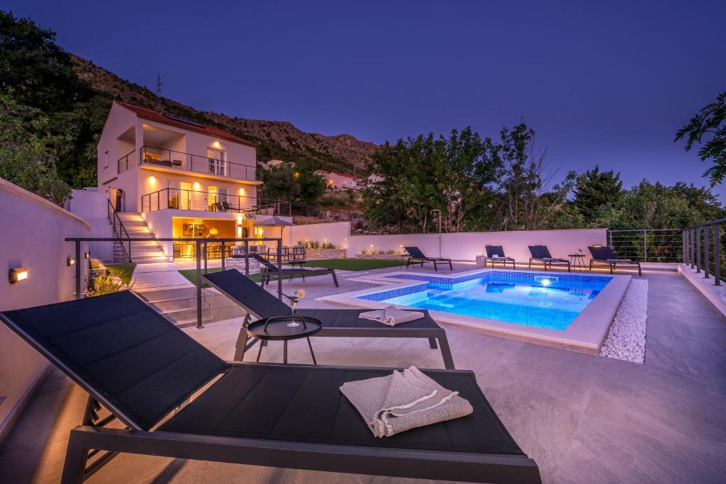 a villa with a swimming pool at night at Villa Maris in Mlini