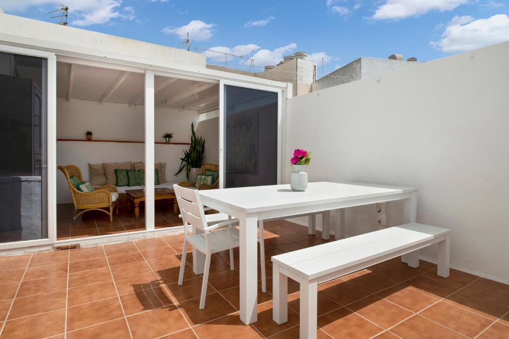 ein Esszimmer mit einem weißen Tisch und Stühlen in der Unterkunft Casa Jenny in Arrecife