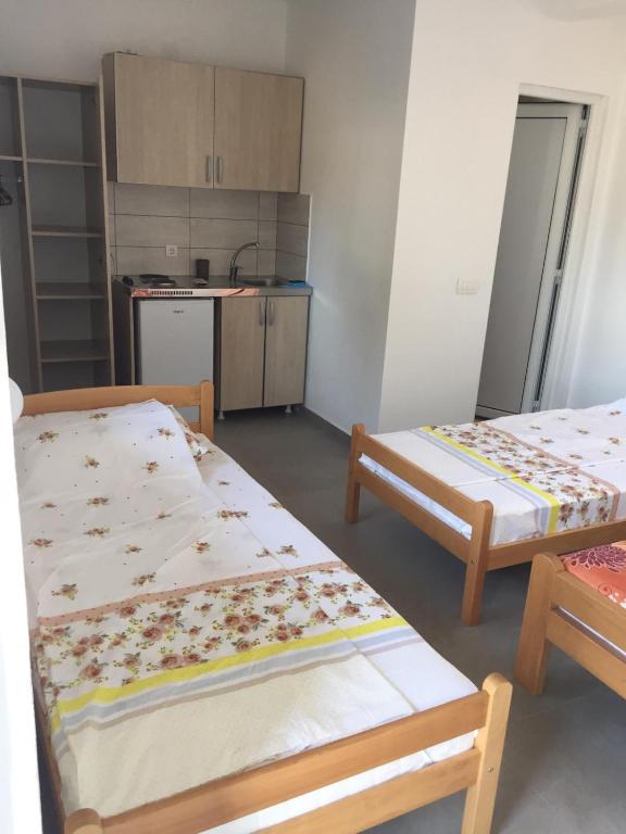 una piccola camera con due letti e una cucina di Apartments 4 u a Donji Štoj