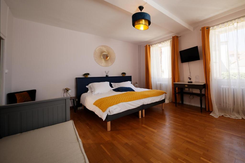 una camera con un letto con una coperta gialla di Les chambres de la vallée a Argenton-Château