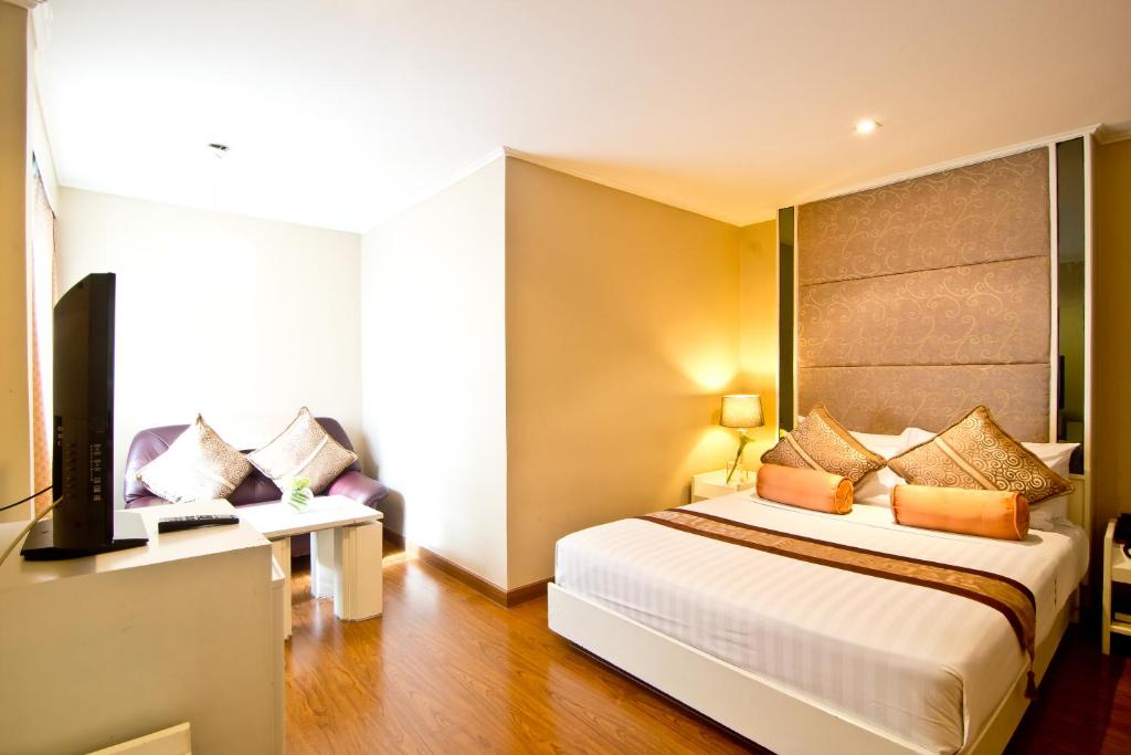 Habitación de hotel con cama y TV en Fortuna Hotel, en Bangkok