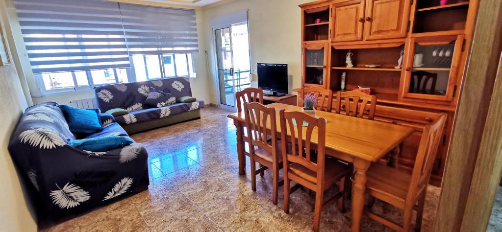 een woonkamer met een tafel en stoelen en een bank bij Apartamento Turístico Playa de Peñiscola in Peñíscola