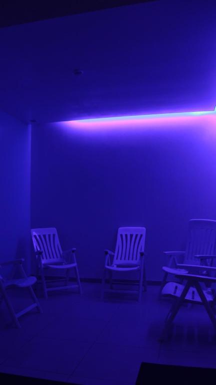 a row of chairs in a room with a blue light at Hotel Monte Lírio in Espinho