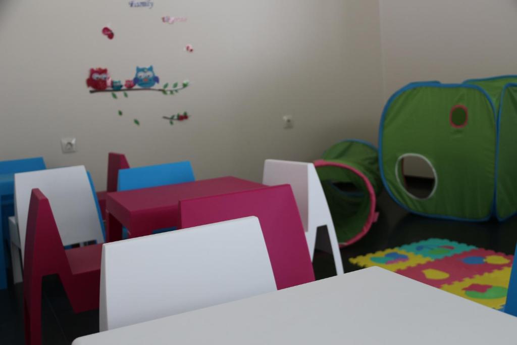 a childs room with colorful chairs and a table at Hotel Monte Lírio in Espinho