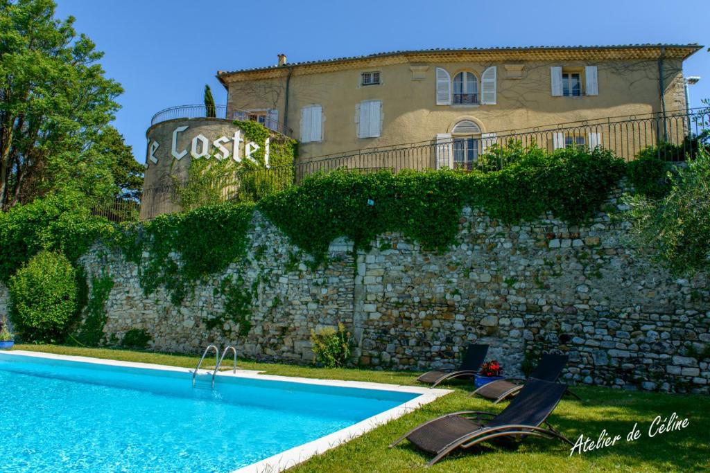 a swimming pool in front of a stone wall and a building at Peaceful retreat in Drome Provencale Castel in Montboucher-sur-Jabron