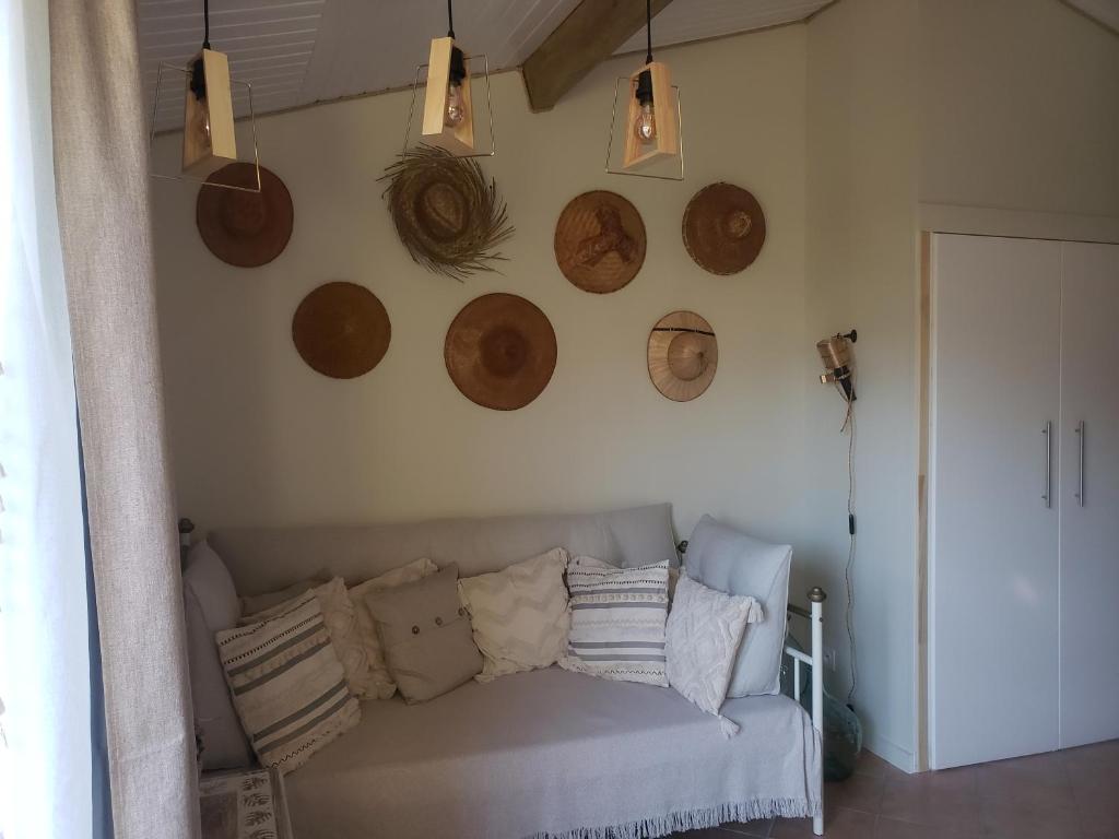 sala de estar con sofá y placas de madera en la pared en Studio Léonie, le cottage de l'étang en Le Tablier