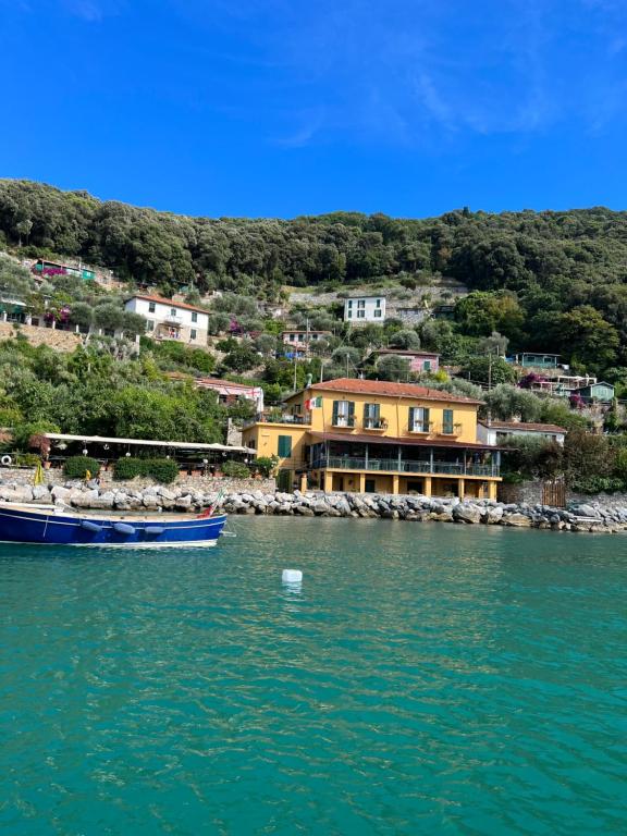 a boat in the water in front of a house at Locanda Lorena in Portovenere