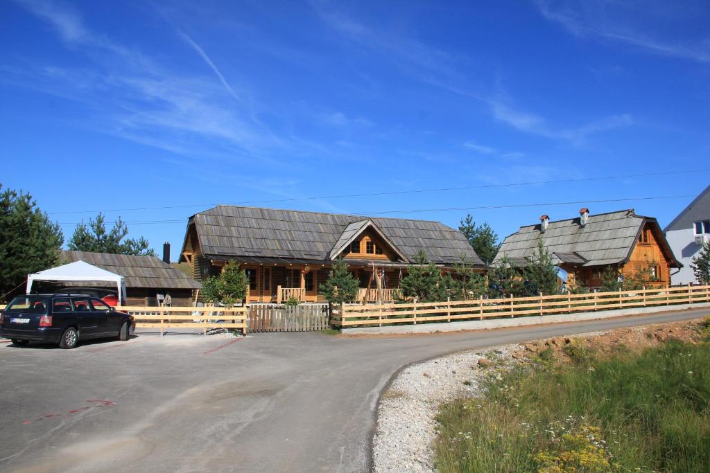 una casa con una valla y un coche aparcado delante de ella en Brvnara Zlatibor Tornik en Zlatibor