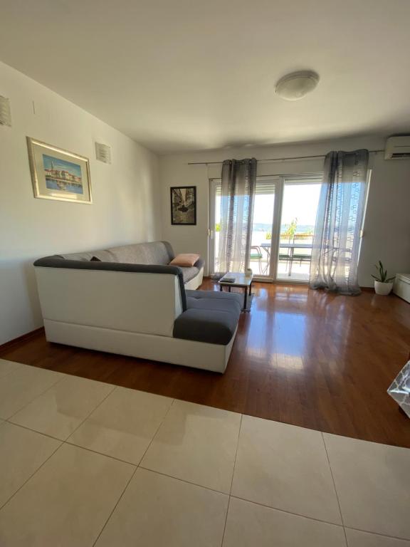 un soggiorno con divano bianco e pavimenti in legno di Apartman Mila a Kaštela (Castelli)