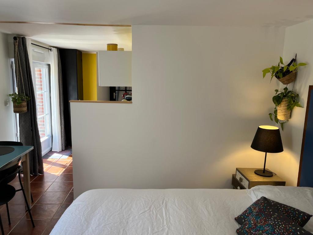 a bedroom with a bed and a table with a lamp at Gîte cosy sur jardin in Moëlan-sur-Mer