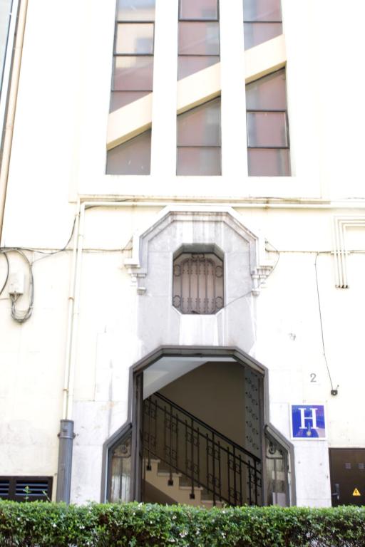 a white building with a balcony in front of it at Hotel Boutique Rosal Oviedo in Oviedo