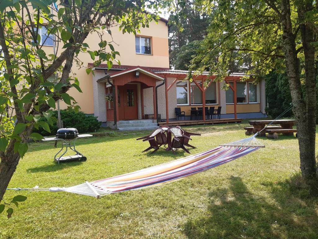 a hammock in a yard in front of a house at Jõesuu Home Accommodation in Purtsi
