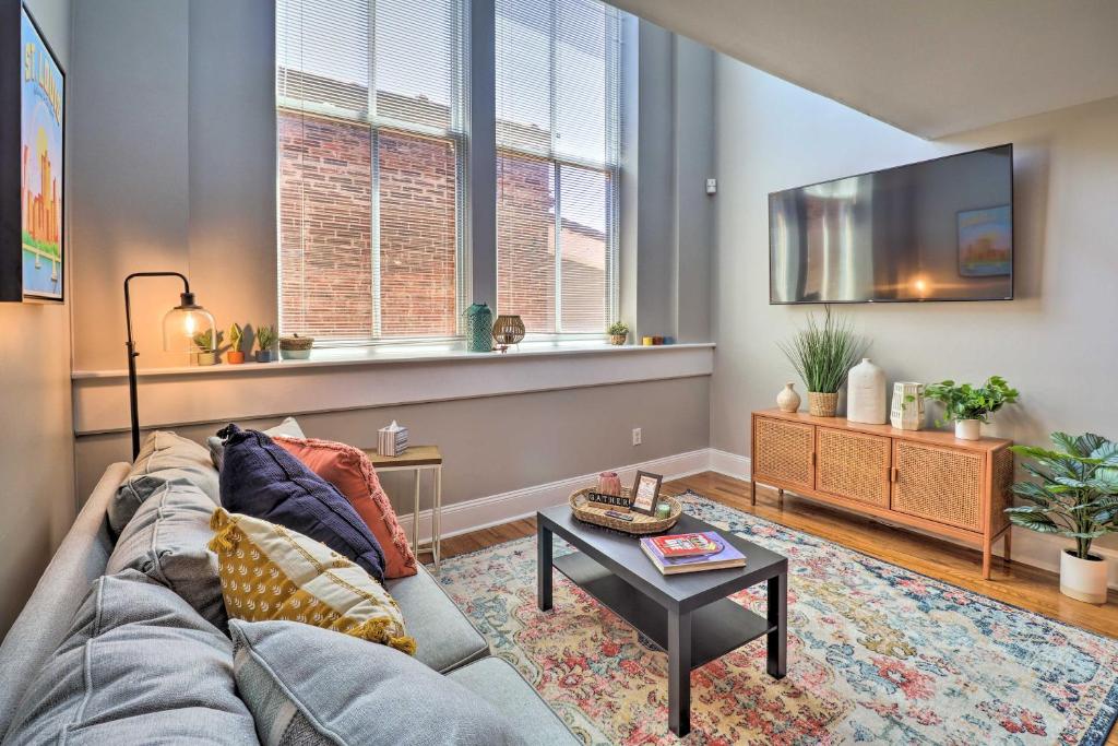 a living room with a couch and a tv at St Louis Apartment Walk to Eating and Entertainment in Tower Grove