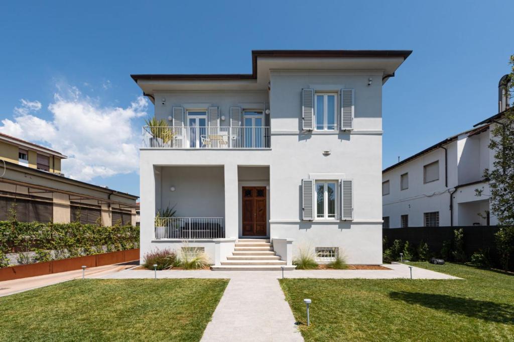 una casa bianca con cortile di Villa Fedora Luxury Suites a Lucca
