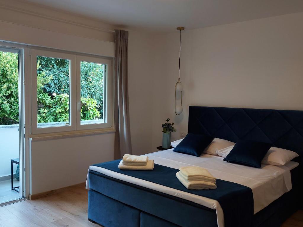 sypialnia z niebieskim łóżkiem i 2 ręcznikami w obiekcie Meden Apartment w Poreču