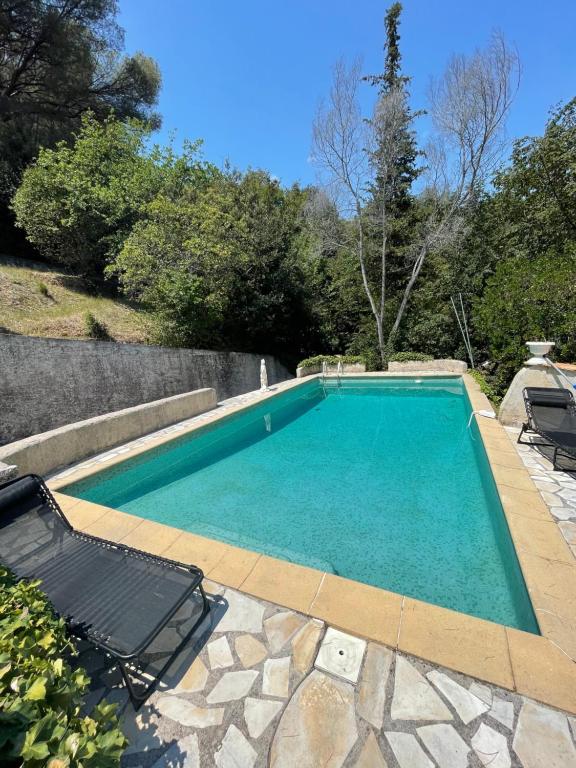 une piscine avec deux chaises longues à côté dans l'établissement Studio en bas de villa avec piscine proche bord de mer, à Cagnes-sur-Mer