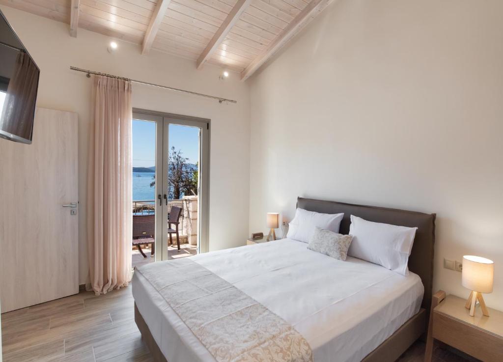 a bedroom with a bed with a view of the ocean at Nikolaos Apartment in Nydri