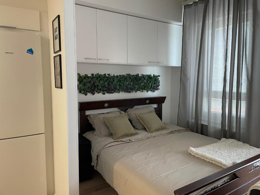 - une chambre dotée d'un lit avec une plante verte au-dessus dans l'établissement lux home, à Tampere
