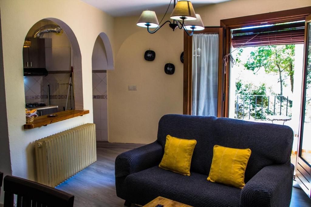 Una sala de estar con un sofá y una ventana. en Apartamentos Vista Veleta, en Capileira