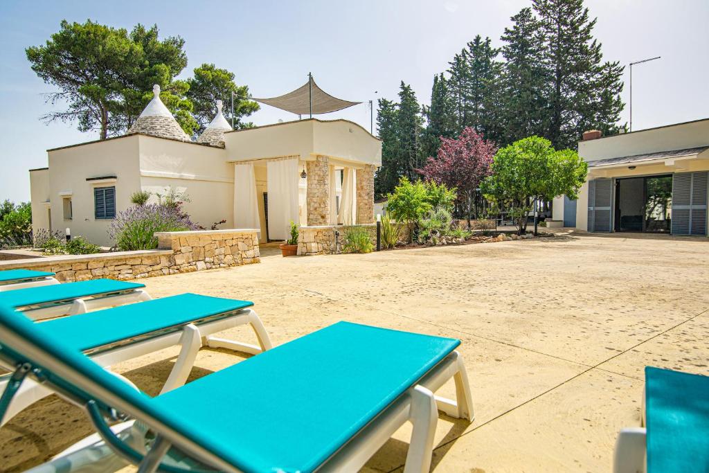 um grupo de mesas de piquenique em frente a um edifício em TRULLI MELOGINO with private beach volley camp em Ostuni