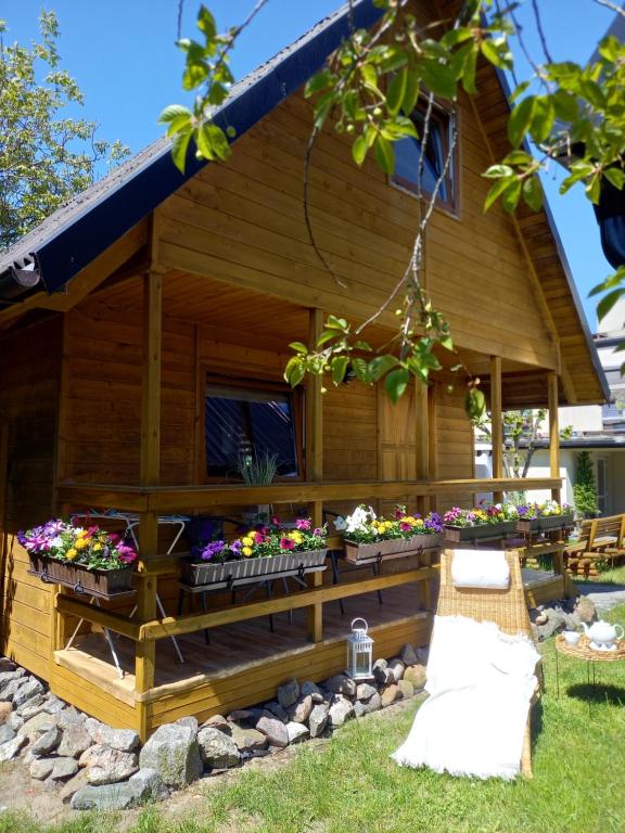 a house with flowers in the front of it at Domek Bałtycki Lux in Rewa