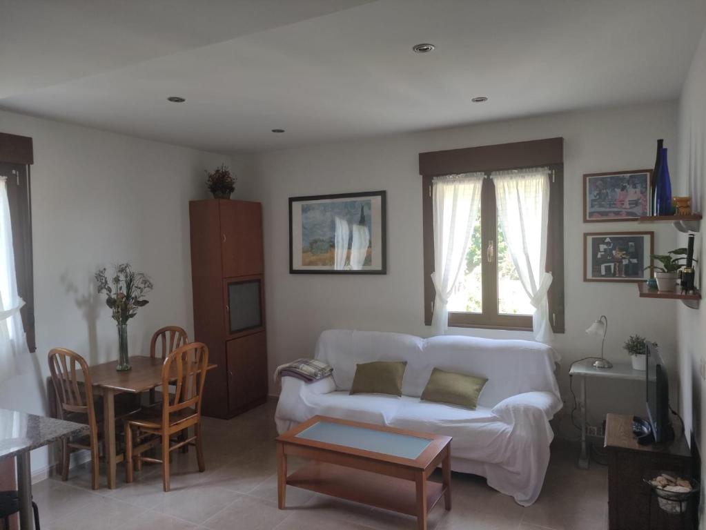 sala de estar con sofá blanco y mesa en Apartamento Tazones, en Tazones