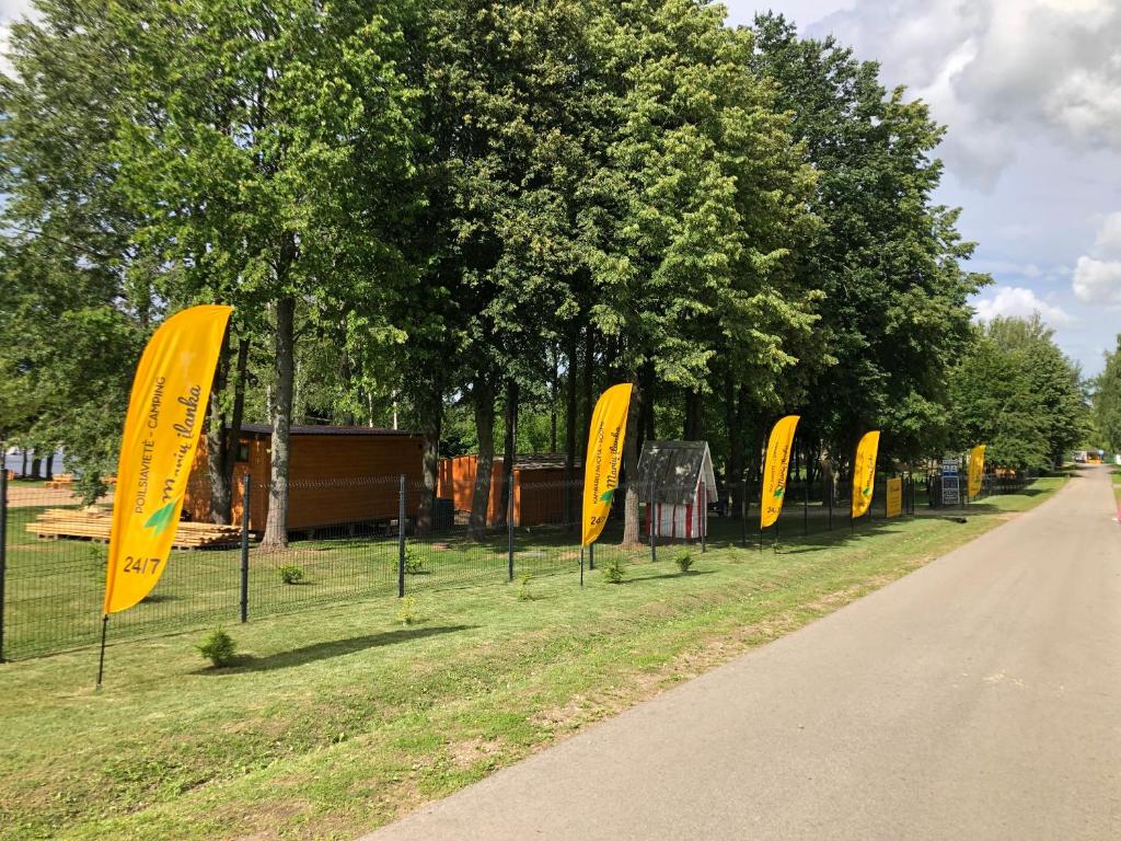 a row of yellow signs on the side of a road at Marių įlanka camping in Marijampolė