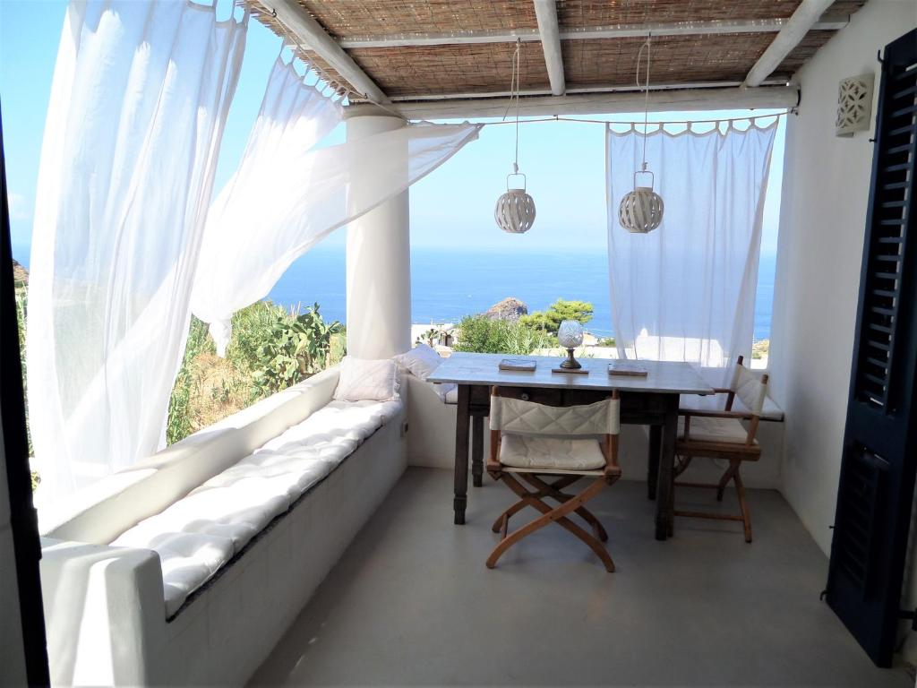 a dining room with a table and a view of the ocean at Casa Capperina in Malfa