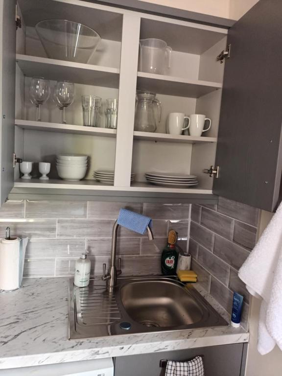 eine Küchenspüle mit Tellern und Geschirr auf Regalen in der Unterkunft Parkhill House Self Catering in Ballyshannon
