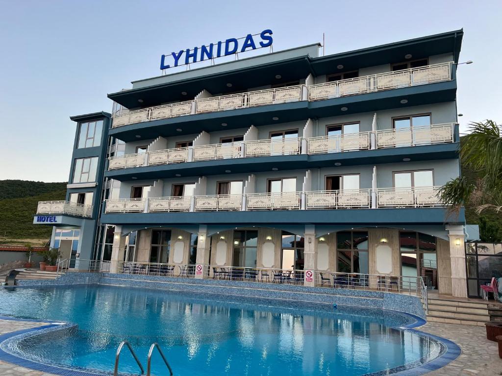 a hotel with a swimming pool in front of it at Hotel Lyhnidas in Pogradec