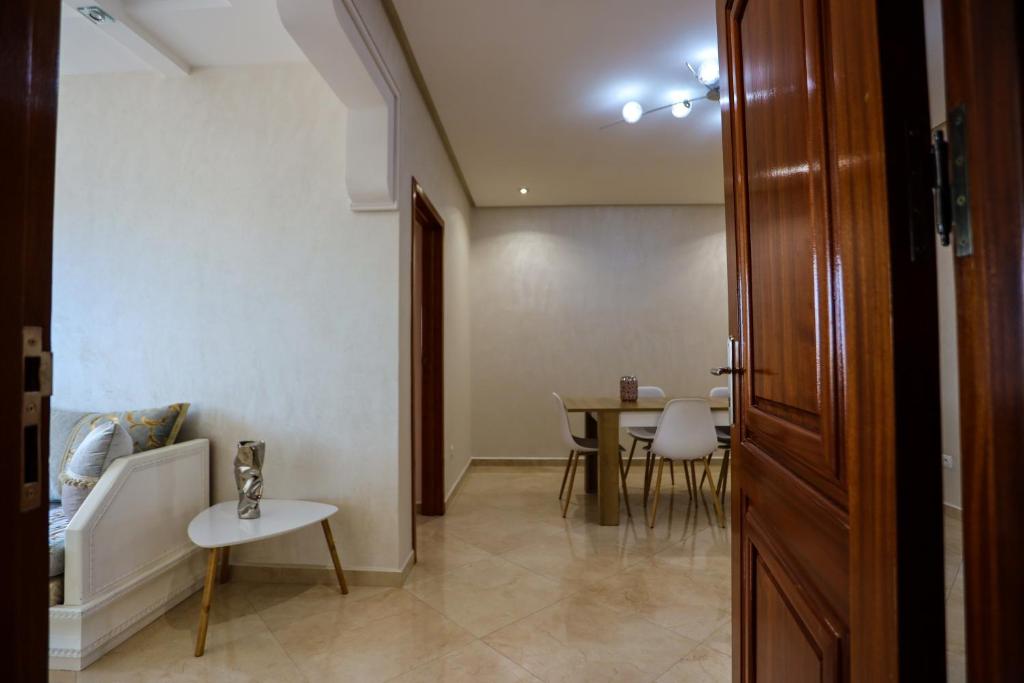 een kamer met een tafel en stoelen en een deur bij LA PERLE RARE in Agadir