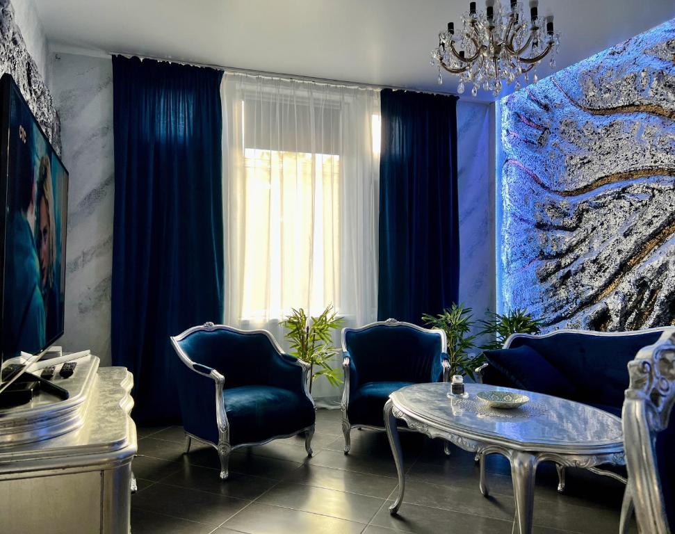 a living room with blue curtains and a table and chairs at Luxus Design Apartments in Plauen