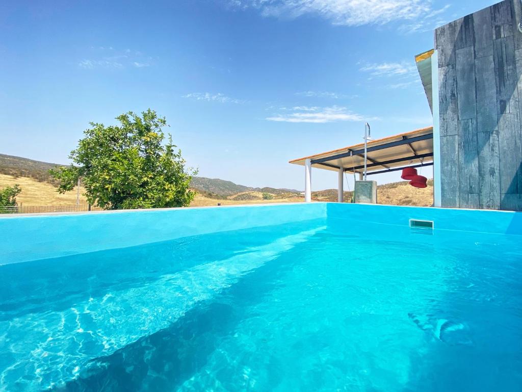 een zwembad met blauw water in een huis bij Casa dos chocalhos-Piscina-Perto Praia Fluvial-Vista incrível e sossego in Mértola