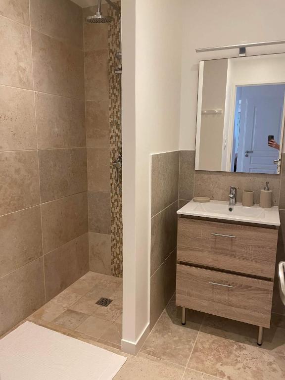 łazienka z umywalką i lustrem w obiekcie Gîte Les Muguets - 4 personnes - confort et vue imprenable w mieście Largentière