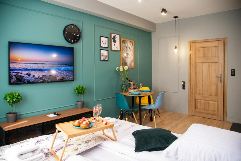 um quarto com uma parede azul com uma cama e uma mesa em Maya's Flats & Resorts 60 - Most Miłości em Gdansk