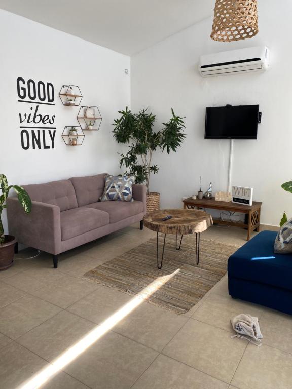 uma sala de estar com um sofá e uma televisão em Moderna casa con piscina a 10 min de la playa em Coclé