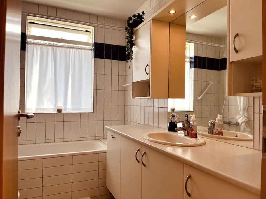 a bathroom with a sink and a tub and a mirror at Sunnuhlíð 19 in Akureyri