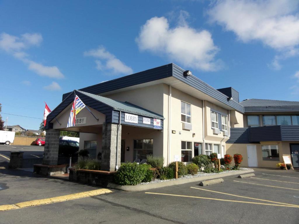 un hotel con un estacionamiento delante de él en Port Augusta Inn, en Comox