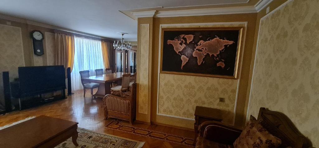 a living room with a table and a painting on the wall at Gold Wall Apartment in Baku