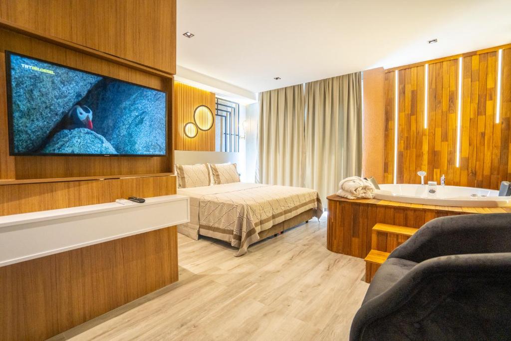 Habitación de hotel con cama, bañera y TV. en Antalya City Hotel & Spa, en Antalya