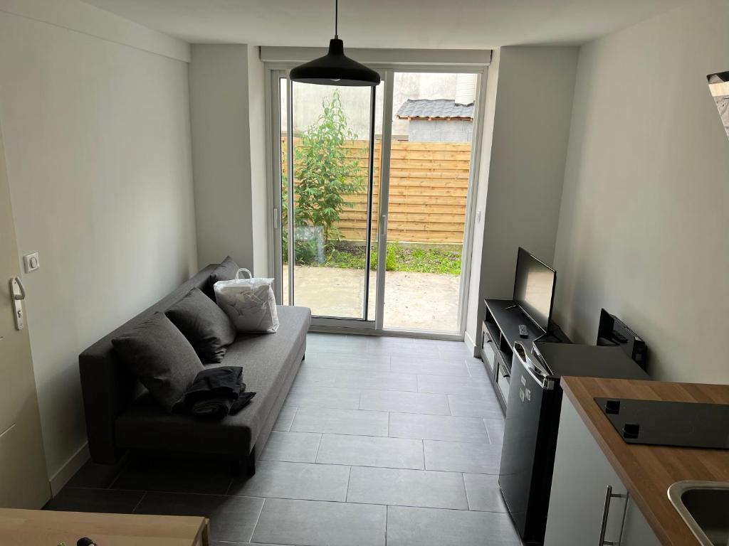 a living room with a couch and a kitchen at Logia in Ploërmel