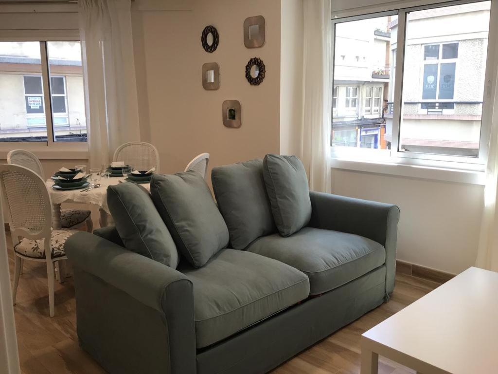 a living room with a blue couch and a table at HyP - Esquina Primavera in A Coruña