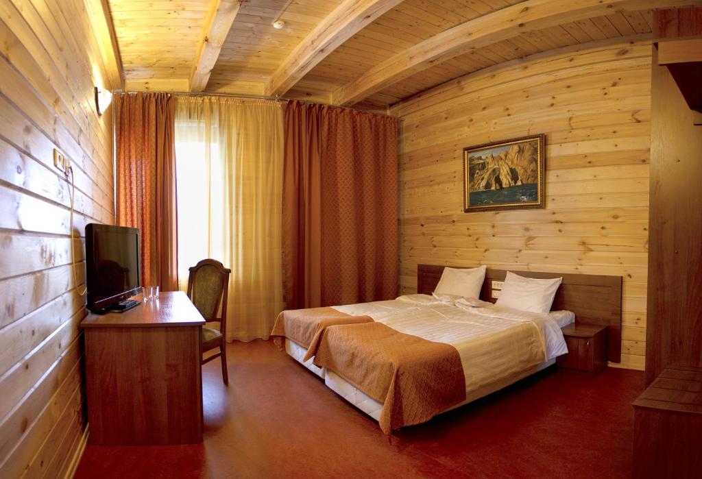 a hotel room with a bed and a television at Sanatory Nekhama in Kazan