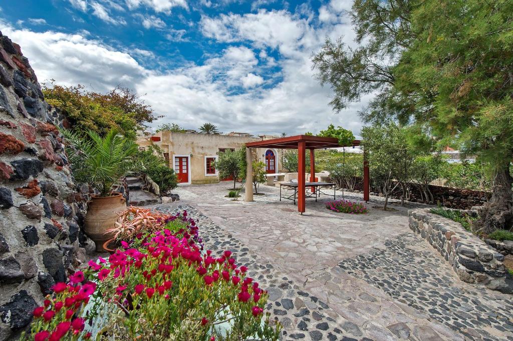 a garden with a gazebo and flowers at 3Arches by Thireon in Oia